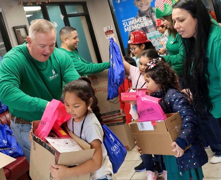 Flint Hills Resources employees distribute gifts to students.